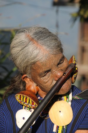 Kvinna från Chin state - tatuerad, spelar flöjt med näsan